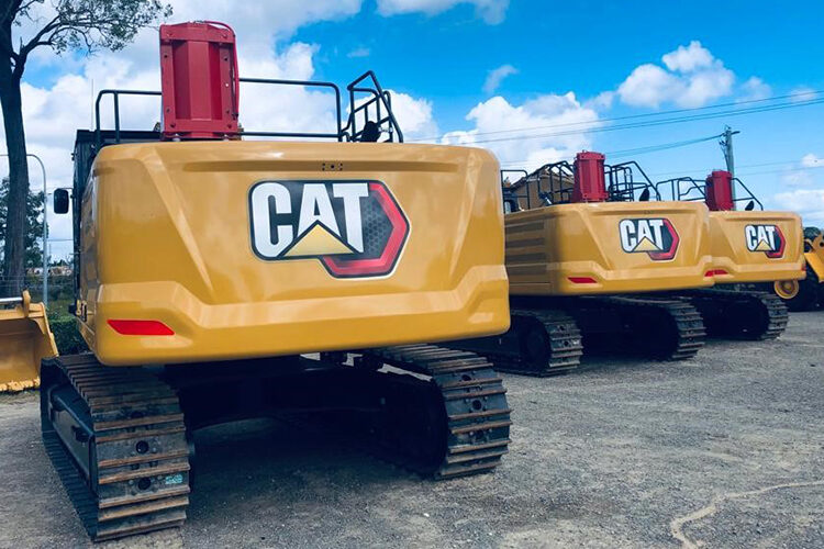 Three Caterpillar 345 GC excavators fitted with Muster suppression cylinders, lined up before export