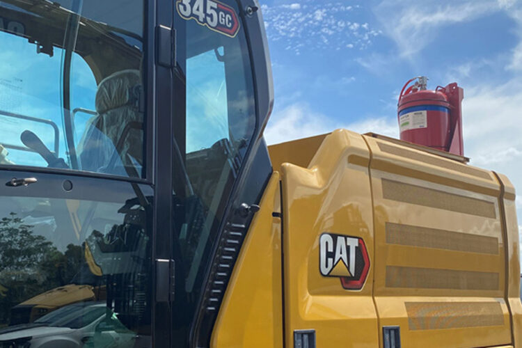 Muster foam suppression cylinder mounted behind the cab of a Caterpillar 345 GC excavator